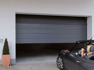 Geöffnetes graues Garagen-Sektionaltor ohne Sicke mit einem Cabrio davor